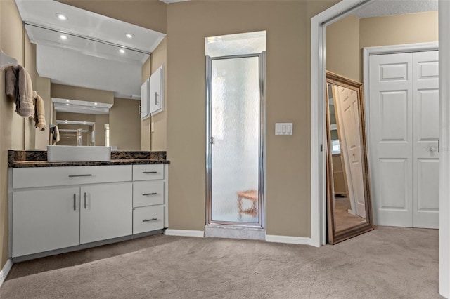 bathroom featuring walk in shower and vanity