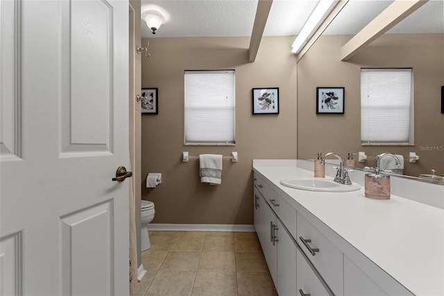 bathroom with vanity, toilet, a textured ceiling, and tile patterned floors