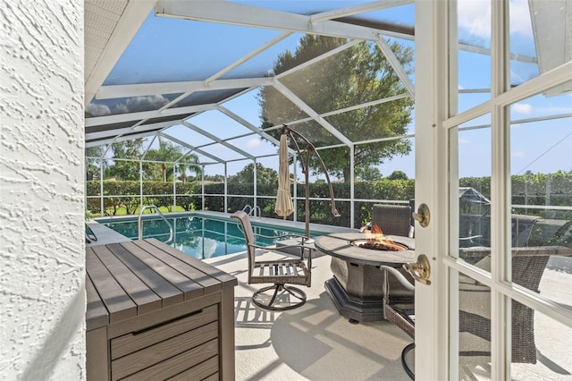 view of pool with glass enclosure, a patio, and an outdoor fire pit