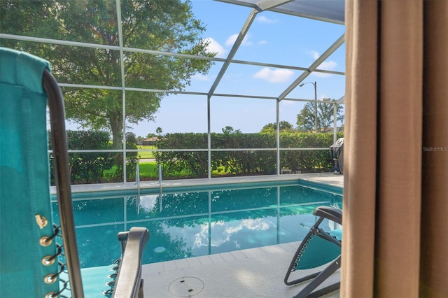 view of swimming pool featuring a lanai