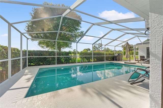 view of swimming pool featuring a patio and a lanai