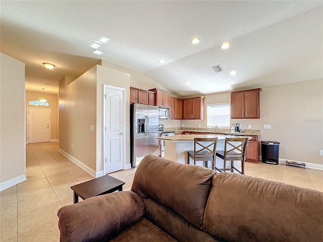 tiled living room with sink, a textured ceiling, and vaulted ceiling