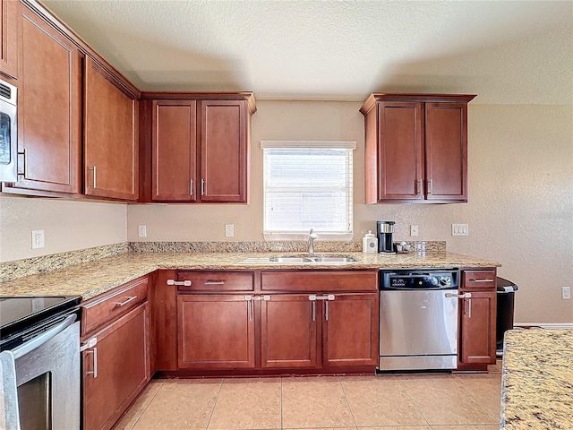 kitchen featuring light stone countertops, sink, stainless steel appliances, a textured ceiling, and light tile patterned floors