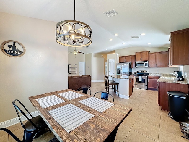 dining area with light tile patterned flooring, ceiling fan with notable chandelier, vaulted ceiling, and sink