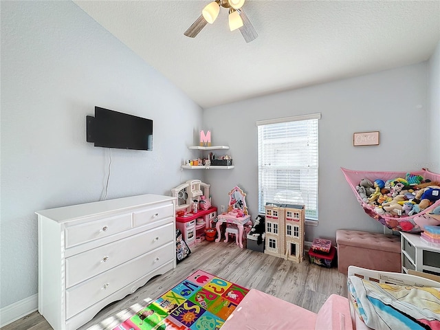 rec room featuring ceiling fan, vaulted ceiling, and light hardwood / wood-style flooring