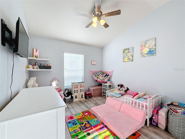 bedroom featuring ceiling fan, lofted ceiling, and light wood-type flooring