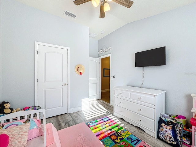 bedroom featuring ceiling fan, light hardwood / wood-style floors, and lofted ceiling