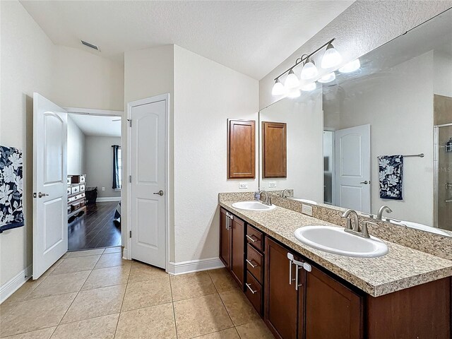 bathroom featuring tile patterned flooring, vanity, and a textured ceiling