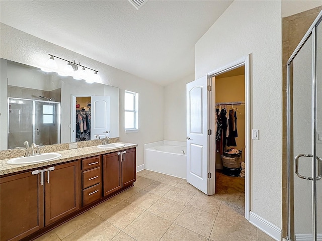 bathroom featuring tile patterned flooring, vanity, and shower with separate bathtub