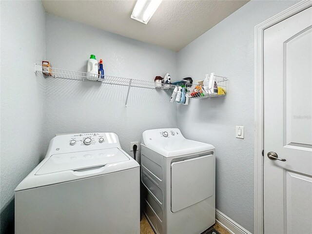 laundry room with independent washer and dryer and a textured ceiling