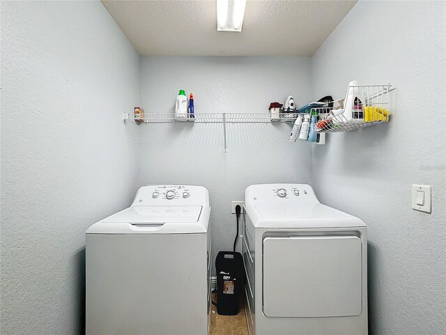 washroom with washer and clothes dryer and a textured ceiling