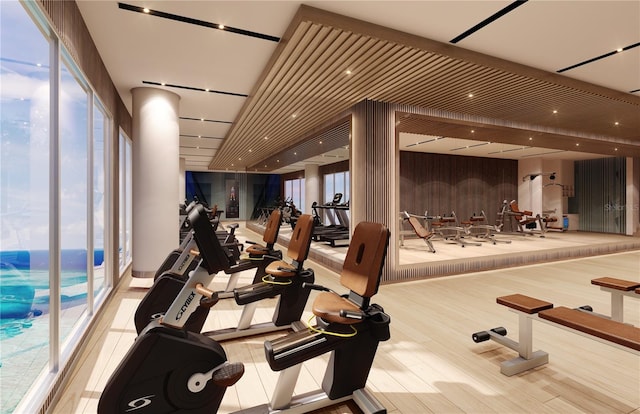 workout area with light hardwood / wood-style flooring and wooden walls