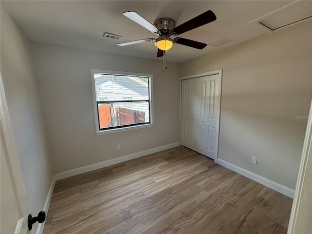 unfurnished bedroom with a closet, light hardwood / wood-style floors, and ceiling fan