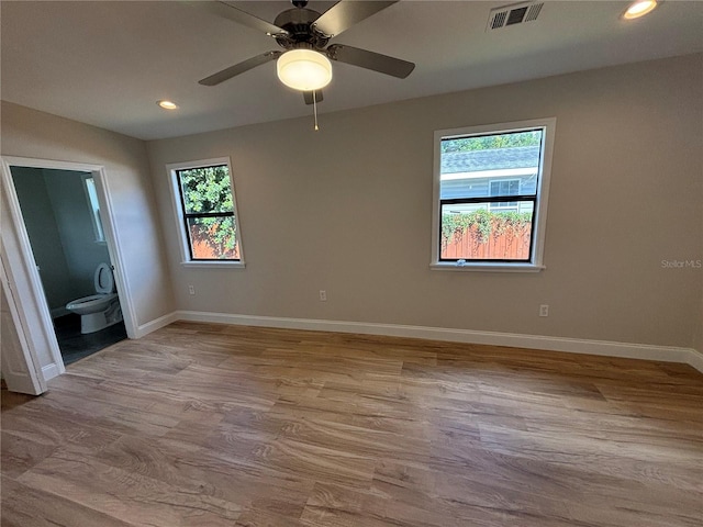 unfurnished bedroom with ceiling fan, ensuite bath, and light hardwood / wood-style floors