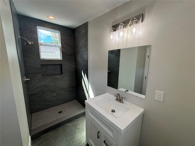 bathroom with tile patterned floors, vanity, and tiled shower