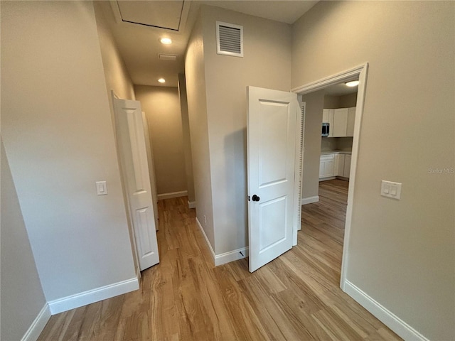 hallway with light hardwood / wood-style floors