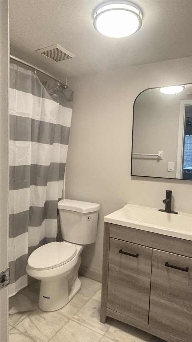 bathroom featuring tile patterned floors, curtained shower, vanity, and toilet