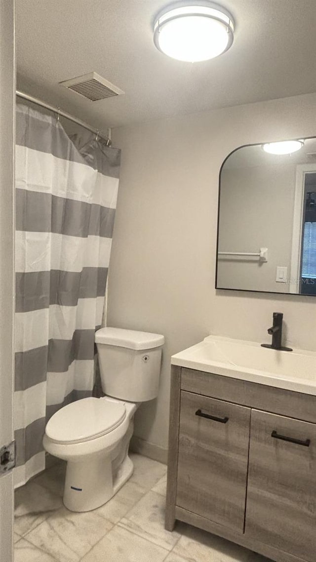 3002 W Cleveland St Unit E1, Tampa, FL 33609 - bathroom featuring vanity, toilet, curtained shower, tile patterned floors, and baseboards