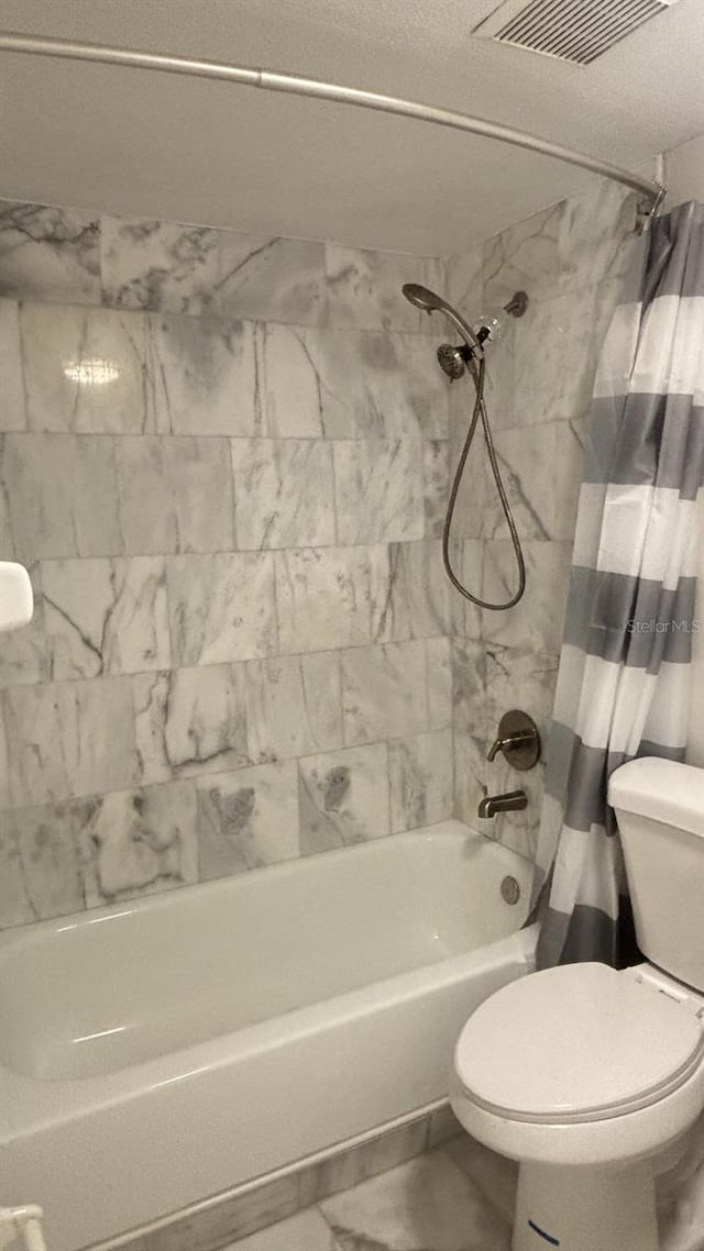 3002 W Cleveland St Unit E1, Tampa, FL 33609 - bathroom with shower / tub combo, toilet, and marble look tiles