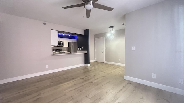 unfurnished living room featuring ceiling fan and light hardwood / wood-style flooring