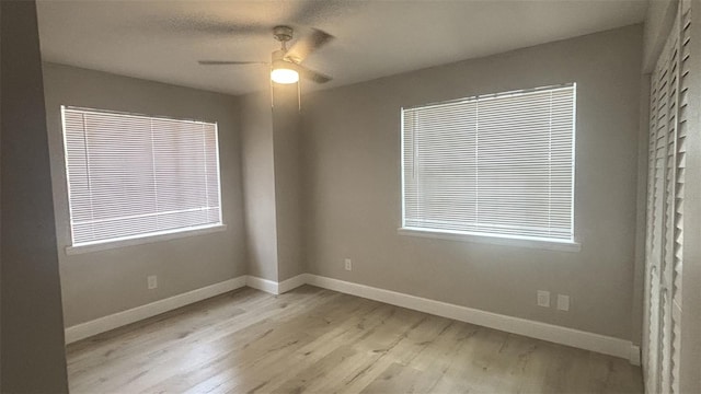 empty room with light hardwood / wood-style floors, ceiling fan, and a healthy amount of sunlight