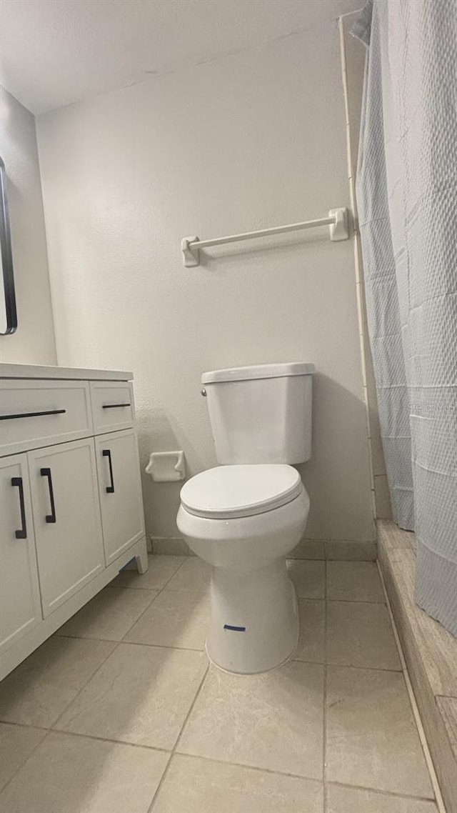 bathroom with tile patterned flooring, a shower with curtain, vanity, and toilet