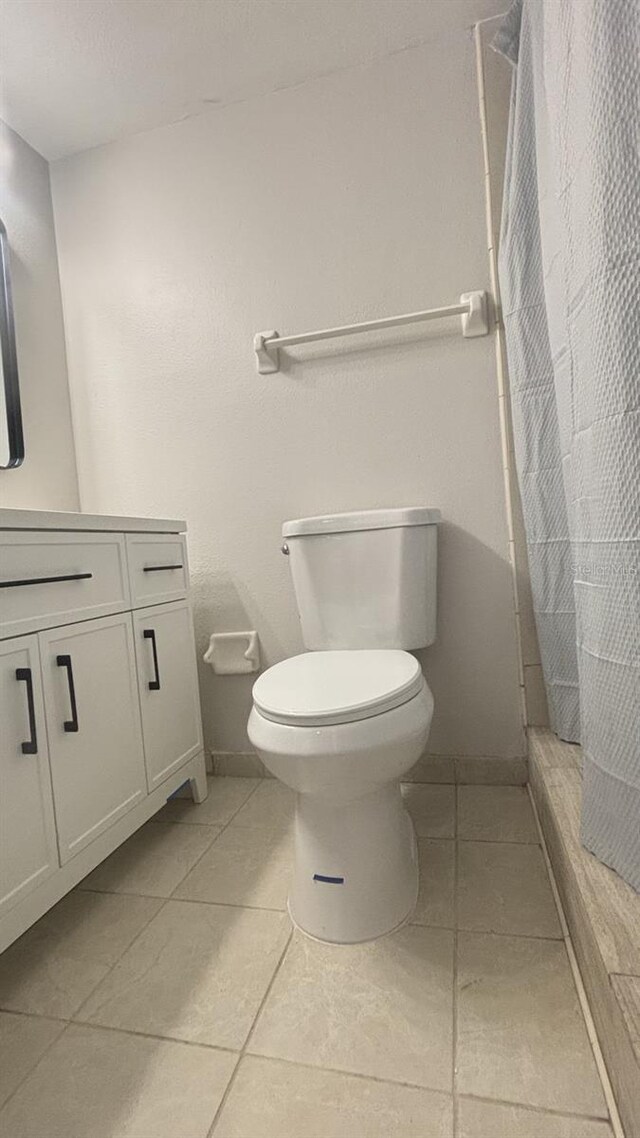 3002 W Cleveland St Unit E1, Tampa, FL 33609 - full bath featuring toilet, vanity, curtained shower, tile patterned floors, and baseboards