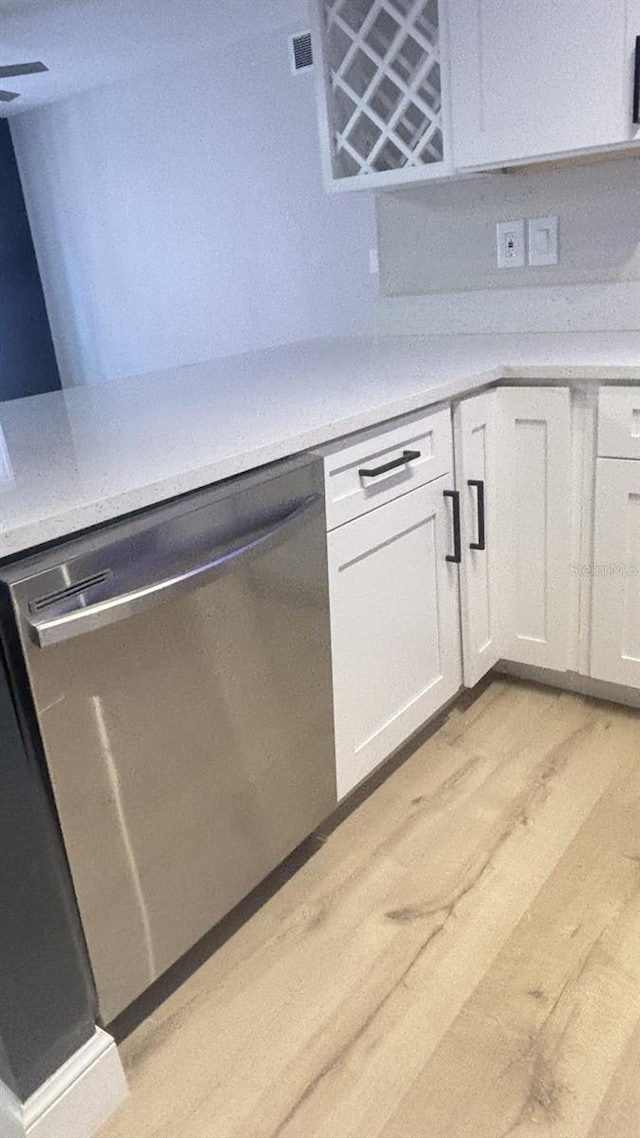 kitchen with light wood-type flooring, white cabinetry, and dishwasher