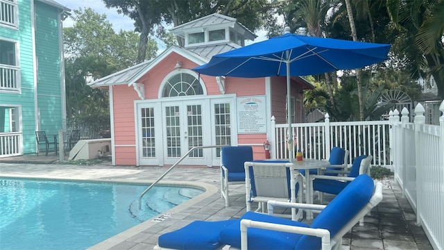 rear view of property with a community pool and a patio