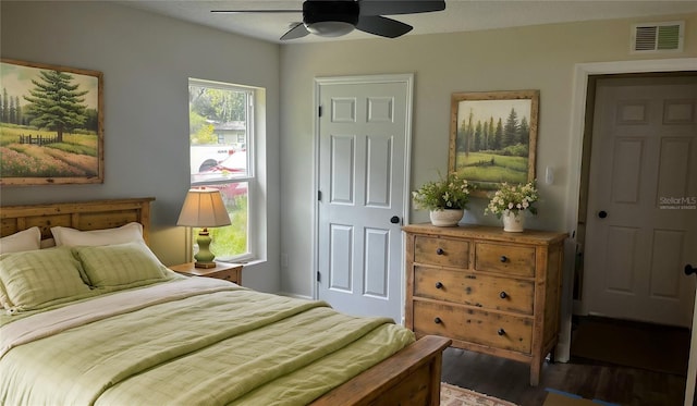 bedroom with dark wood-type flooring, ceiling fan, and multiple windows