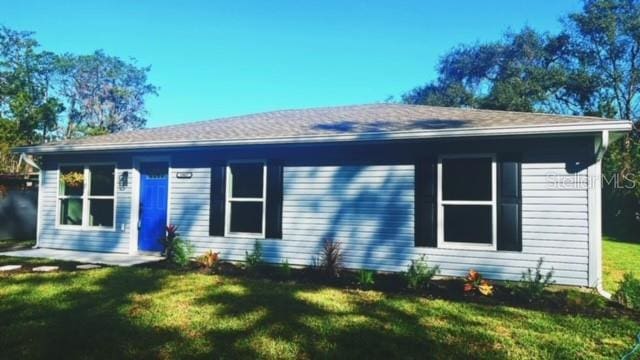 rear view of property featuring a lawn