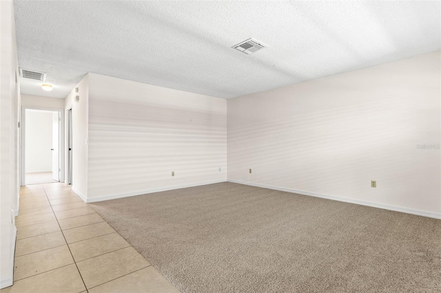 carpeted empty room with a textured ceiling