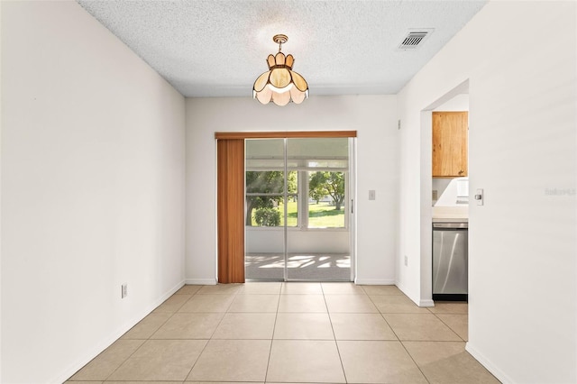 2222 Greenhaven Dr, Sun City Center, FL 33573 - doorway with a textured ceiling, light tile patterned flooring, and baseboards