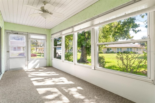 unfurnished sunroom with ceiling fan and plenty of natural light