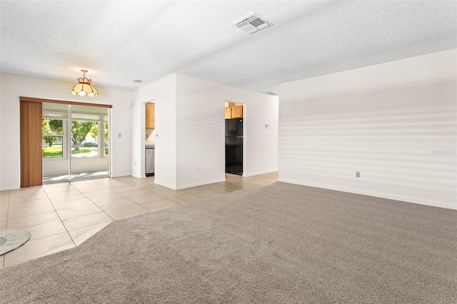 2222 Greenhaven Dr, Sun City Center, FL 33573 - unfurnished room with a textured ceiling, light tile patterned floors, baseboards, and light colored carpet