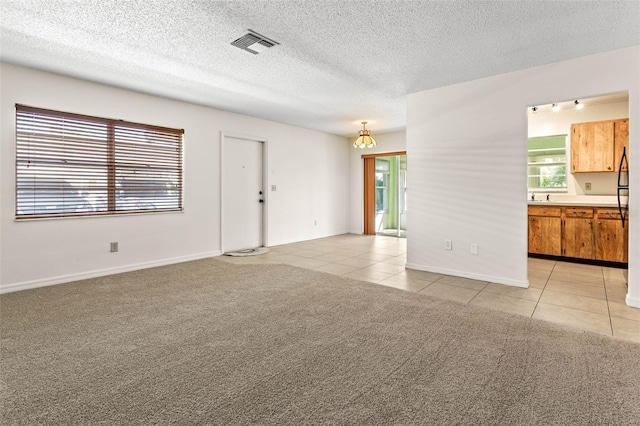 2222 Greenhaven Dr, Sun City Center, FL 33573 - unfurnished living room featuring light tile patterned floors, a textured ceiling, a sink, a chandelier, and light colored carpet