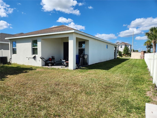 back of property featuring a lawn and central AC unit