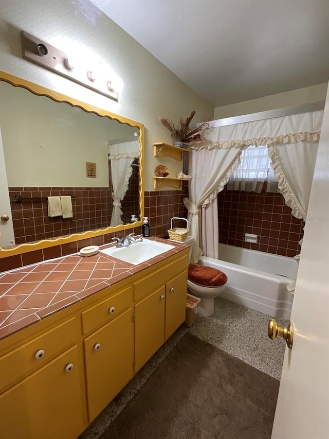 full bathroom with tile walls, vanity, toilet, and tiled shower / bath