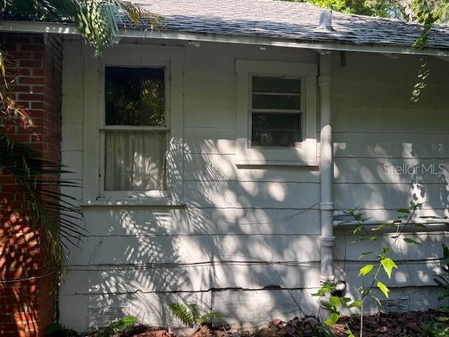 view of property exterior with roof with shingles