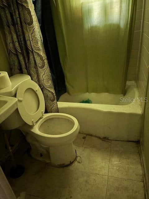 bathroom with shower / tub combo with curtain, toilet, and tile patterned flooring