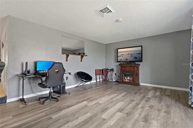 office space with a textured ceiling and light wood-type flooring