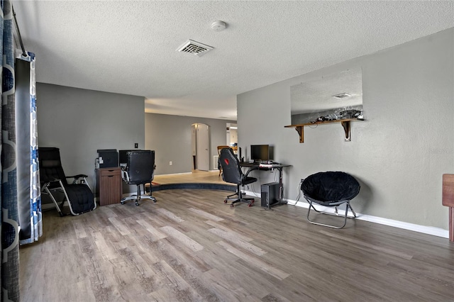 office space with light hardwood / wood-style floors and a textured ceiling