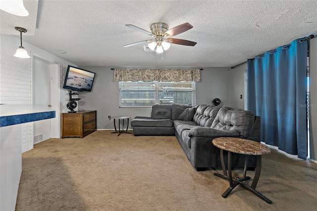 living room with ceiling fan, carpet floors, and a textured ceiling