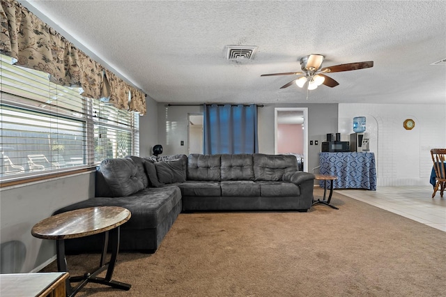 carpeted living room with a textured ceiling and ceiling fan