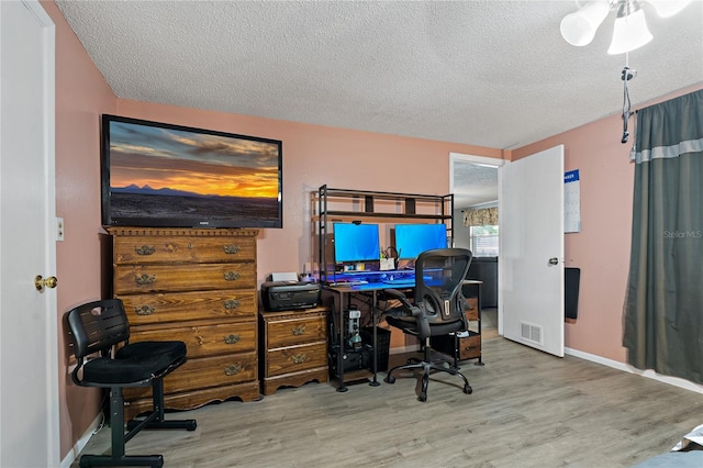 office space with light hardwood / wood-style flooring and a textured ceiling