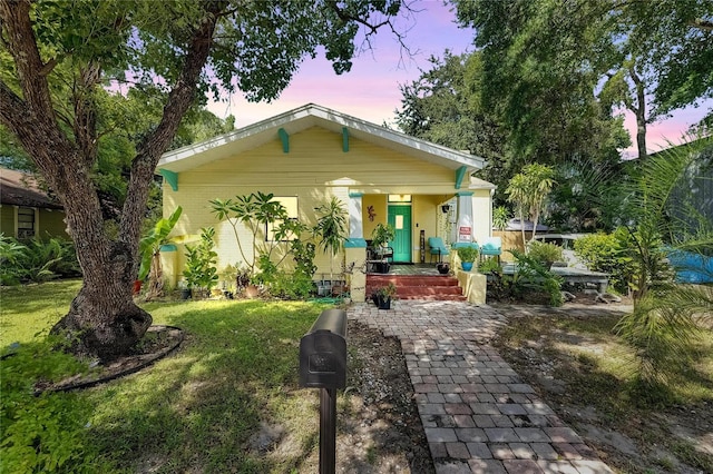 view of front of house featuring covered porch and a yard