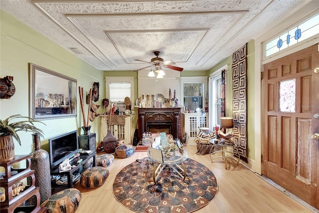 living room featuring ceiling fan, hardwood / wood-style floors, and a textured ceiling