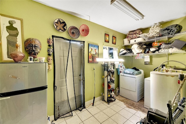 laundry room featuring light tile patterned floors, gas water heater, and washing machine and clothes dryer