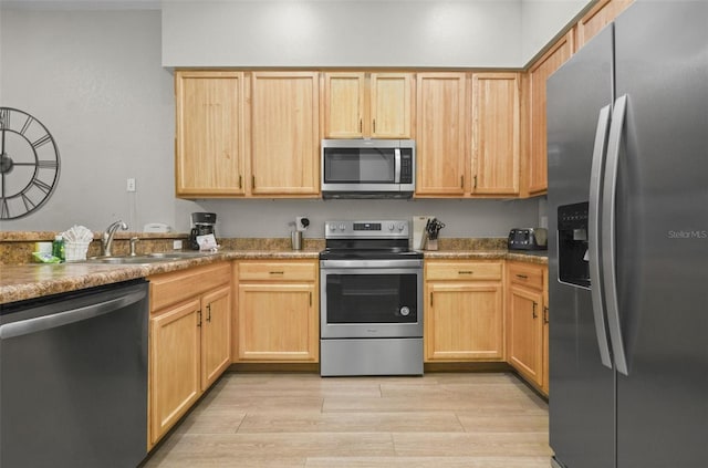 kitchen featuring appliances with stainless steel finishes, light brown cabinetry, and sink