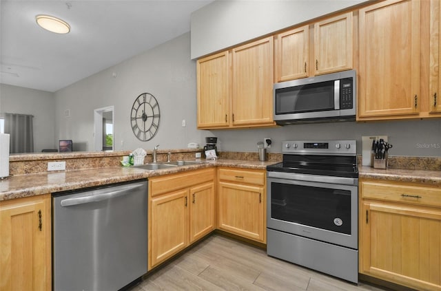 kitchen featuring light brown cabinets, sink, stainless steel appliances, and light hardwood / wood-style floors